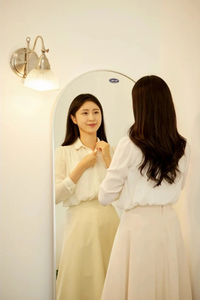 저녁에 거울 앞에서 옷매무새를 다듬는 장면
